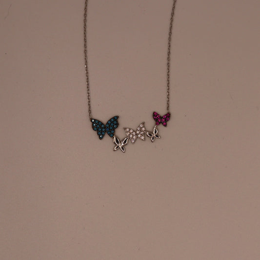 Necklace with butterfly pendants on a beige background
